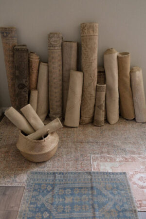 rugs rolled up leaning against a wall